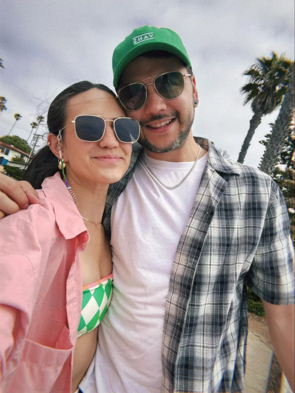 Brian and Nicole in sunglasses under palm trees